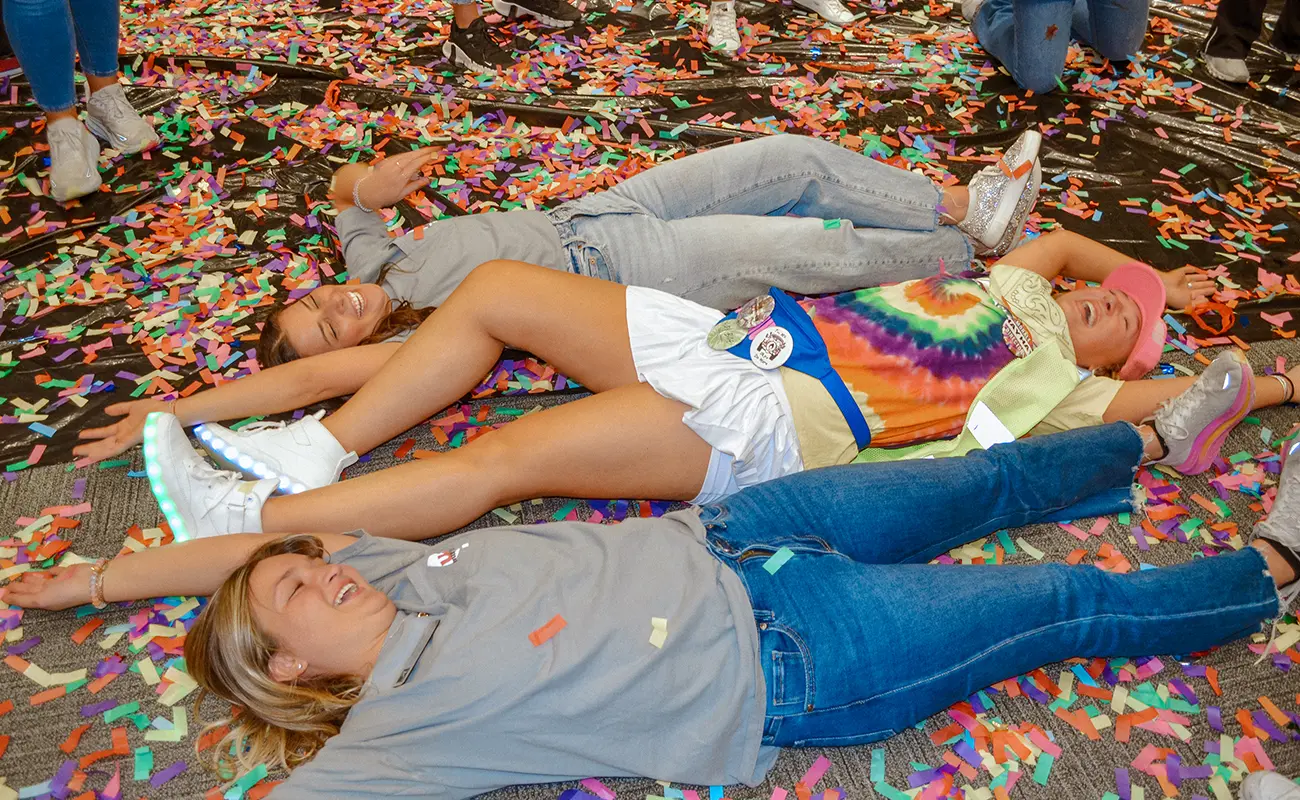 UA Miracle students laughing on the floor, surrounded by confetti