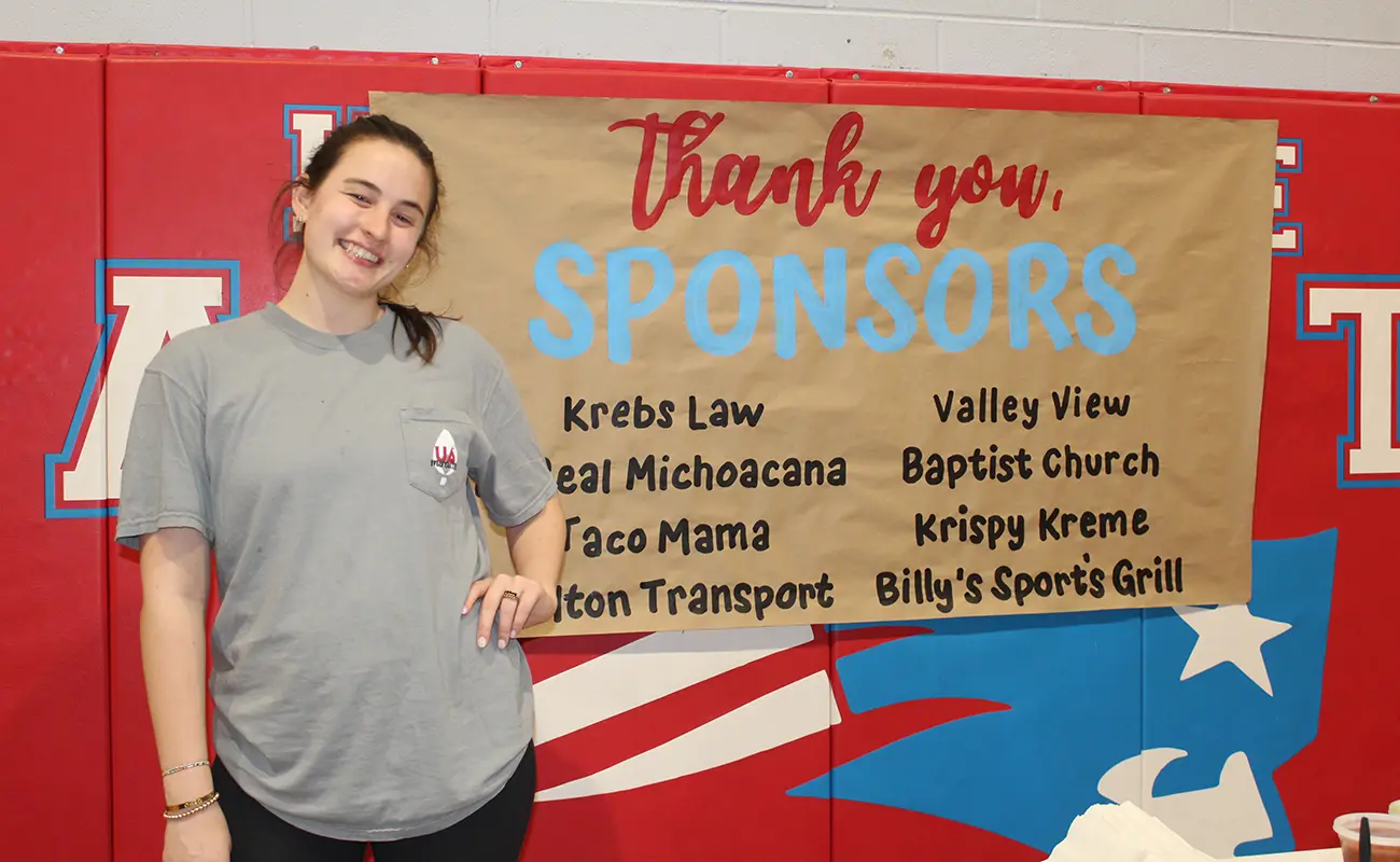 UA Miracle student in front of Thank you, Sponsors sign